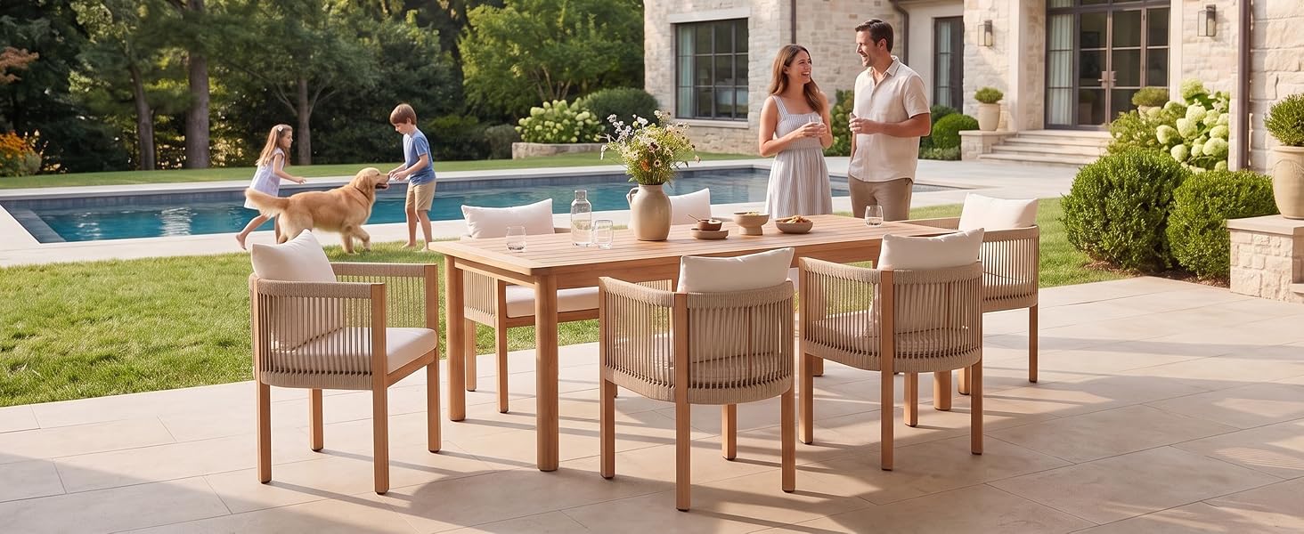 Ensemble de meubles de patio en bois avec table à manger et chaises disposées sur une terrasse en pierre, surplombant le paysage du jardin avec la piscine visible en arrière-plan.