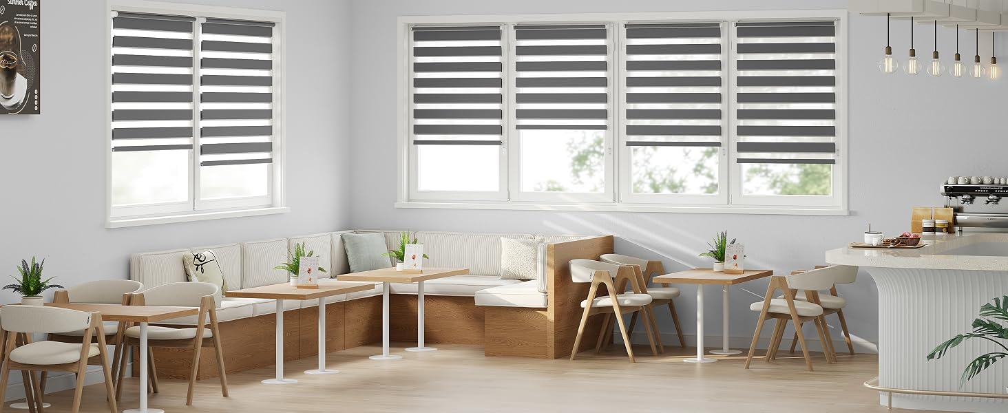 Interior luminoso de la cocina con gabinetes blancos, mesa de comedor de madera, sillas, plantas en macetas y persianas con persianas. Diseño de hogar moderno y minimalista con iluminación natural.