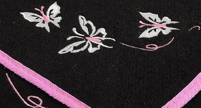 Black fabric decorated with white butterfly embroidery designs and pink piping trim along the edges.