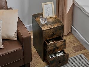 Rustic wooden side table with three drawers, placed next to a brown leather armchair in a living room setting.