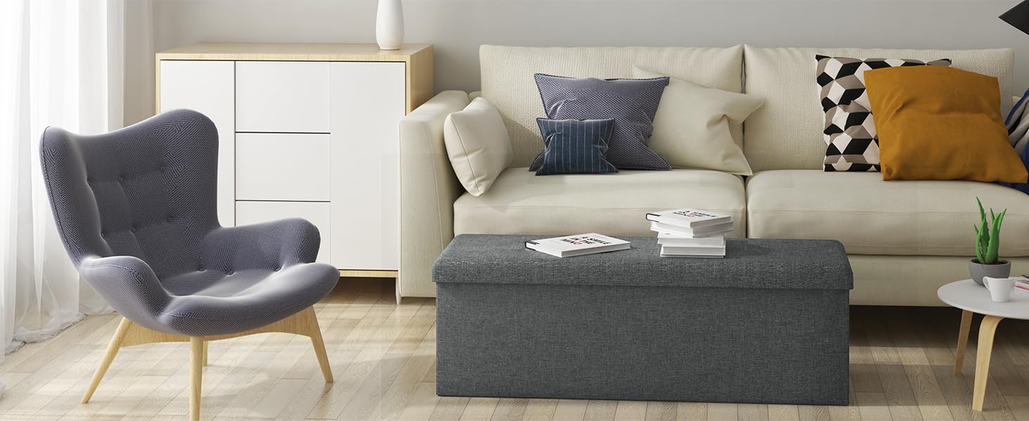 un pouf grigio con un divano bianco e un divano bianco