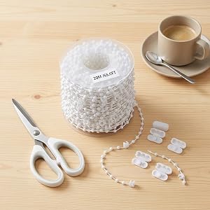 White decorative cake on wooden table with matching serving utensils and accessories, showing detailed lace-like pattern.