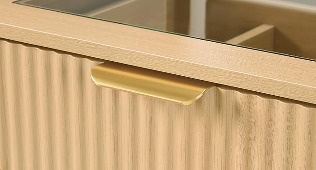 Cajón tipo armario de madera con panel frontal ondulado y tirador empotrado de color latón.