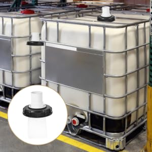 Industrial storage area with multiple white IBC totes (Intermediate Bulk Containers) arranged in rows on metal racks with safety barriers.