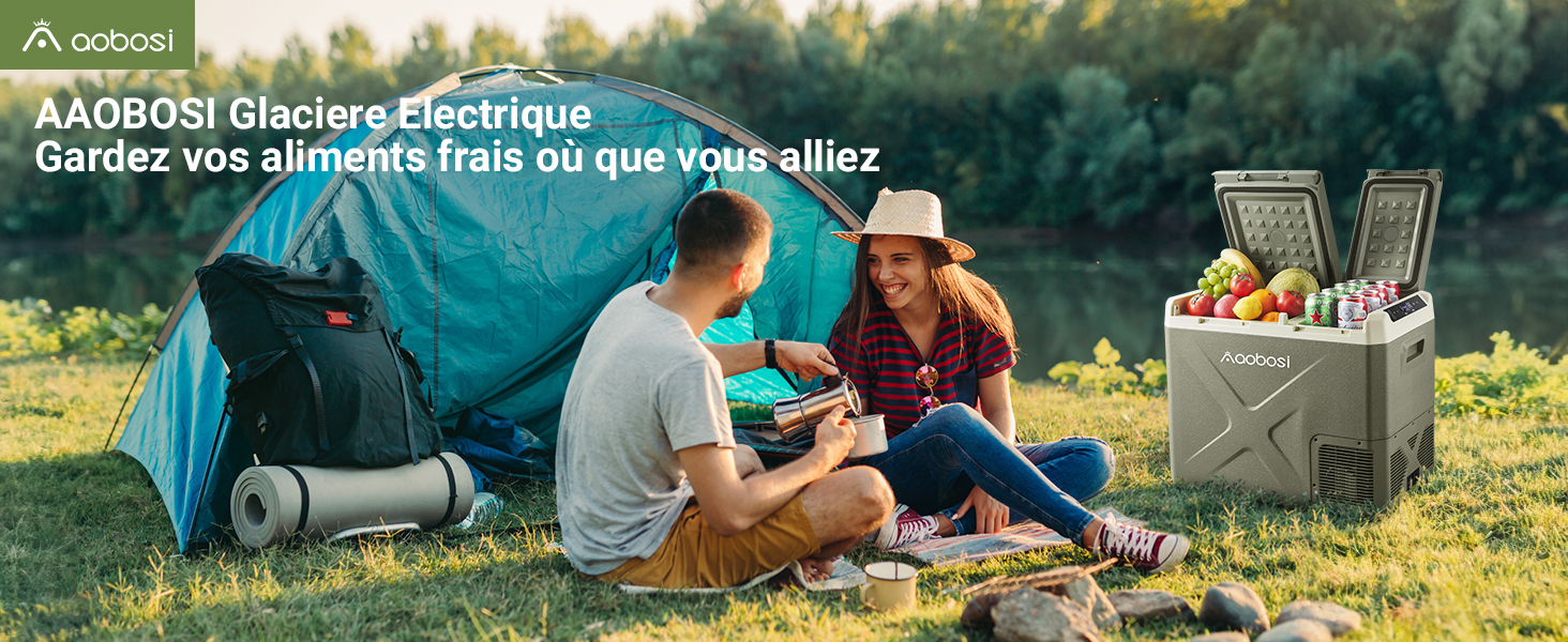 présentée à l'extérieur près d'une tente de camping. Unité de refroidissement grise positionnée à côté de personnes dégustant des aliments frais en pleine nature.