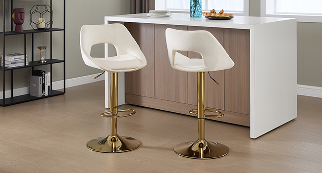 Espace intérieur moderne comprenant une table à manger blanche avec base dorée, associée à des chaises blanches et à des meubles de rangement en bois accrochés au mur.