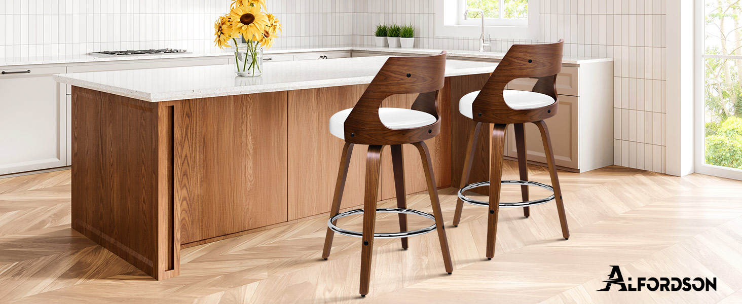 Text reads 'ALFORDSON'. Modern kitchen island with white countertop and wood paneling, featuring two brown walnut-colored barstools with curved backs and white cushions. Sunflowers in vase visible.