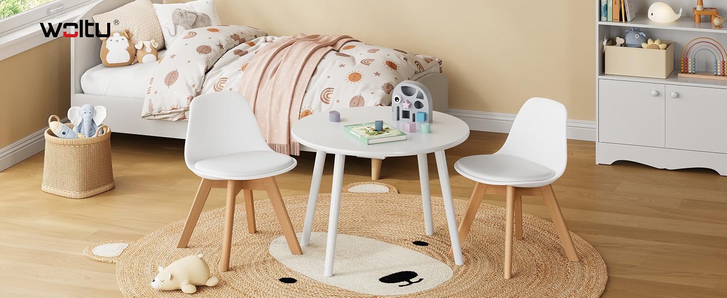 Ambiente interno con mobili per bambini tra cui contenitori bianchi, tavolo rotondo e sedie in una combinazione di colori neutri.
