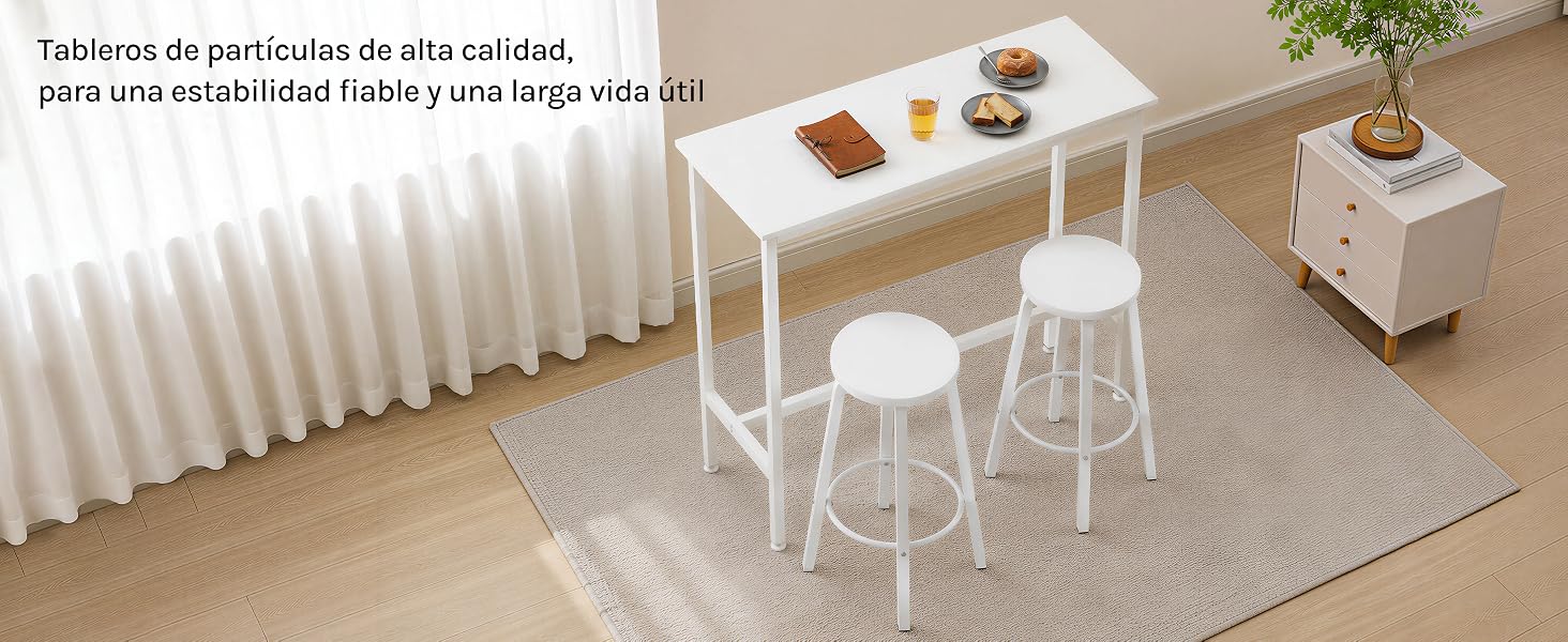 El texto dice «Tableros de partícula de alta calidad, para crear estilo hogar y para café». Juego de escritorio y sillas blancas en miniatura con artículos de café sobre una alfombra de color beige en una habitación a escala de casa de muñecas.