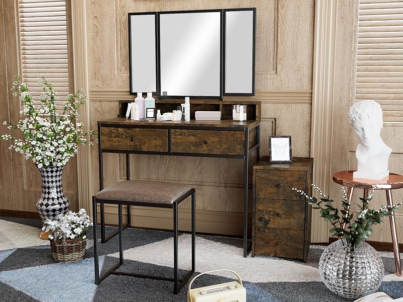 Rustic vanity set with tri-fold mirror, wooden desk, matching stool, and decorative accessories in a vintage-inspired room setting with floral accents and wooden paneling.