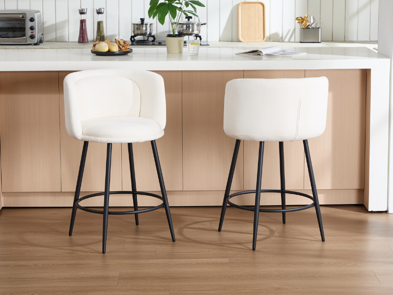 Spazio interno moderno con sedie da pranzo o da ufficio bianche con gambe in metallo nero, accostate a pavimenti in legno chiaro e pareti neutre.
