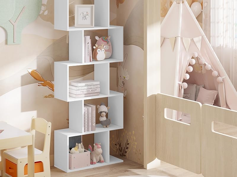 Libreria bianca a zigzag nell'angolo della stanza di un bambino. Mostra libri e giocattoli. Letto a baldacchino adiacente con bordo a pompon. Combinazione di