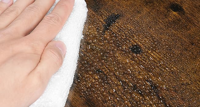 Berührende, kontrastierende Oberflächen: glatte, helle Haut auf rauem, dunkelbraunem, strukturiertem Material mit sichtbaren Fasern und kleinen dunklen Flecken