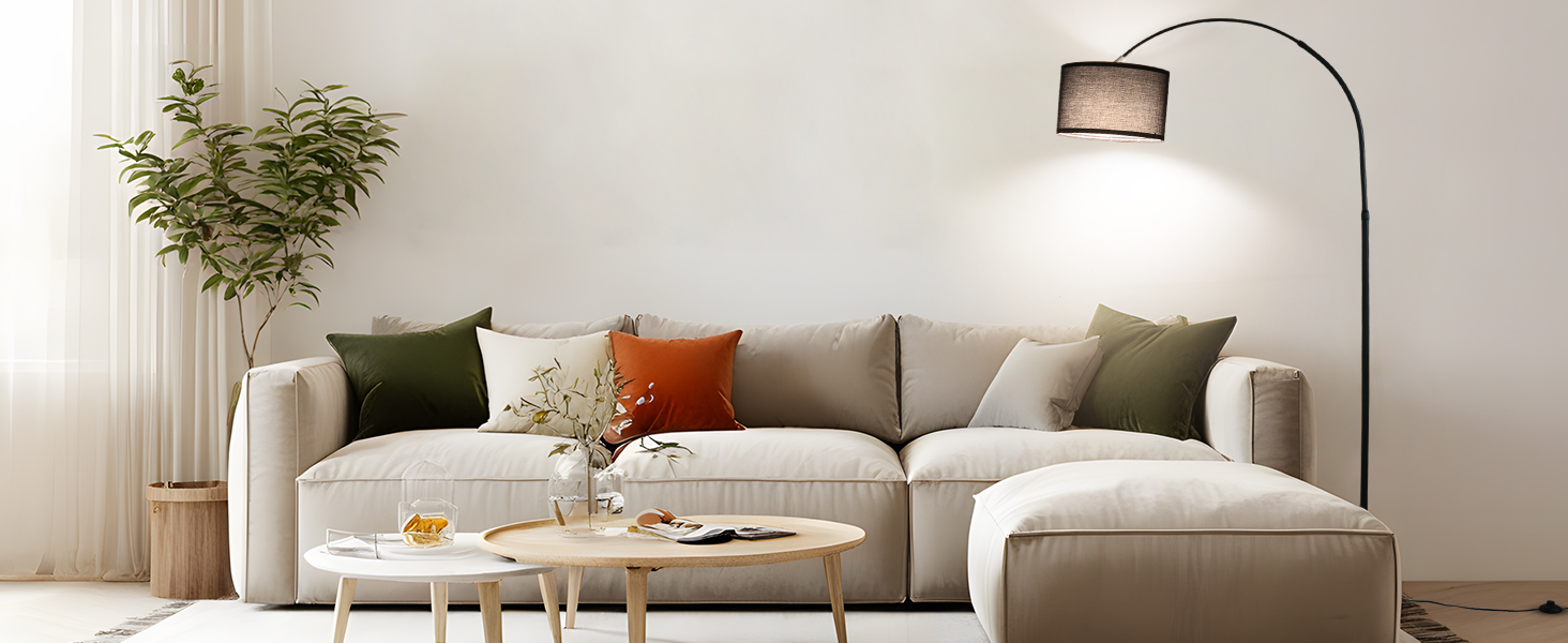 Modernes Wohnzimmer mit beigem L-förmigem Ecksofa, Couchtischen aus Holz, gewölbter Stehlampe und Topfpflanze. Bunte Dekokissen setzen Akzente in dem neutral getönten
