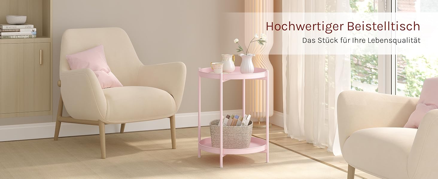 Wohnzimmerszene mit beigen Sesseln, rosafarbenem Beistelltisch und weißen Vorhängen. Der Tisch ist mit Dekorationsgegenständen ausgestattet. Sichtbarer Text: 'Hochwertiger Beistelltisch'