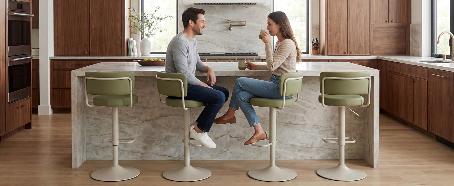 Two people sitting at a white desk with integrated green storage compartments in a modern kitchen with wooden cabinetry, demonstrating functional workspace furniture.