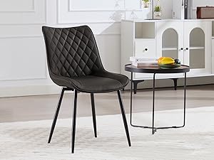 a black dining chair with a black seat and a table in front of it.