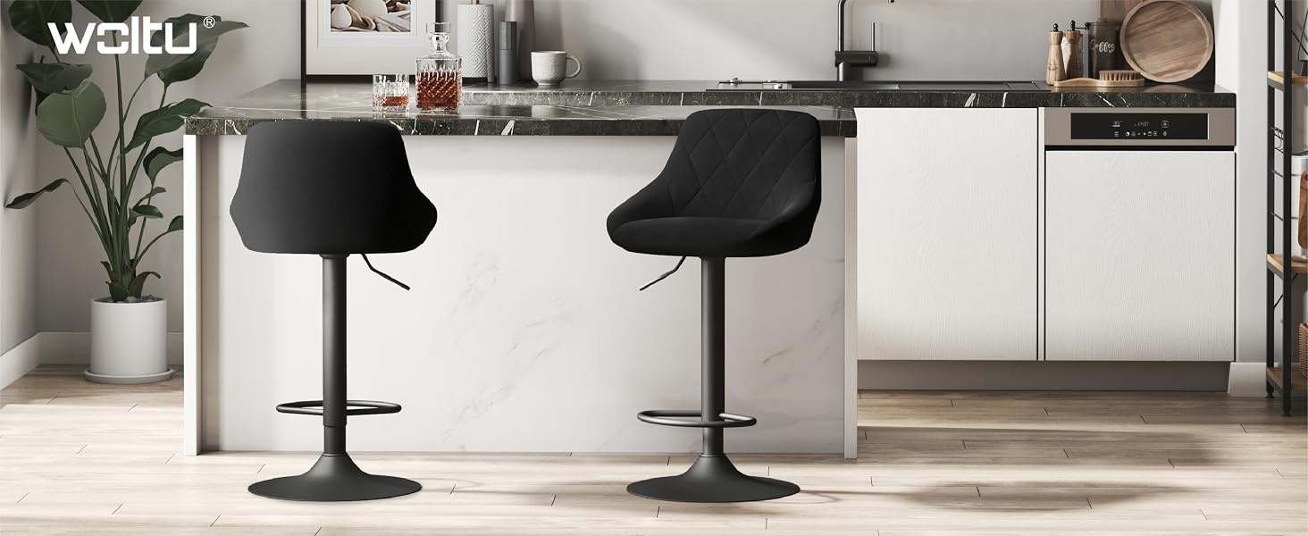 Modern kitchen island with two black adjustable bar stools, white cabinetry, and floating shelves against gray wall.
