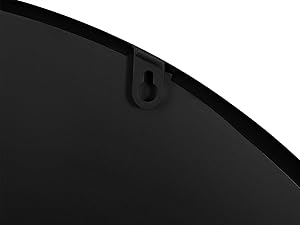 Primer plano del borde de un objeto circular negro, que muestra una superficie curva con un pequeño gancho o percha que sobresale cerca