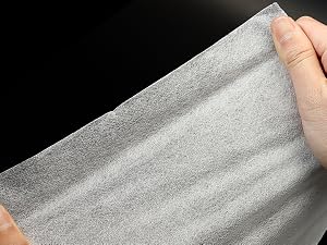 Tirez à la main une feuille de tissu ou de matière douce de couleur claire sur fond noir