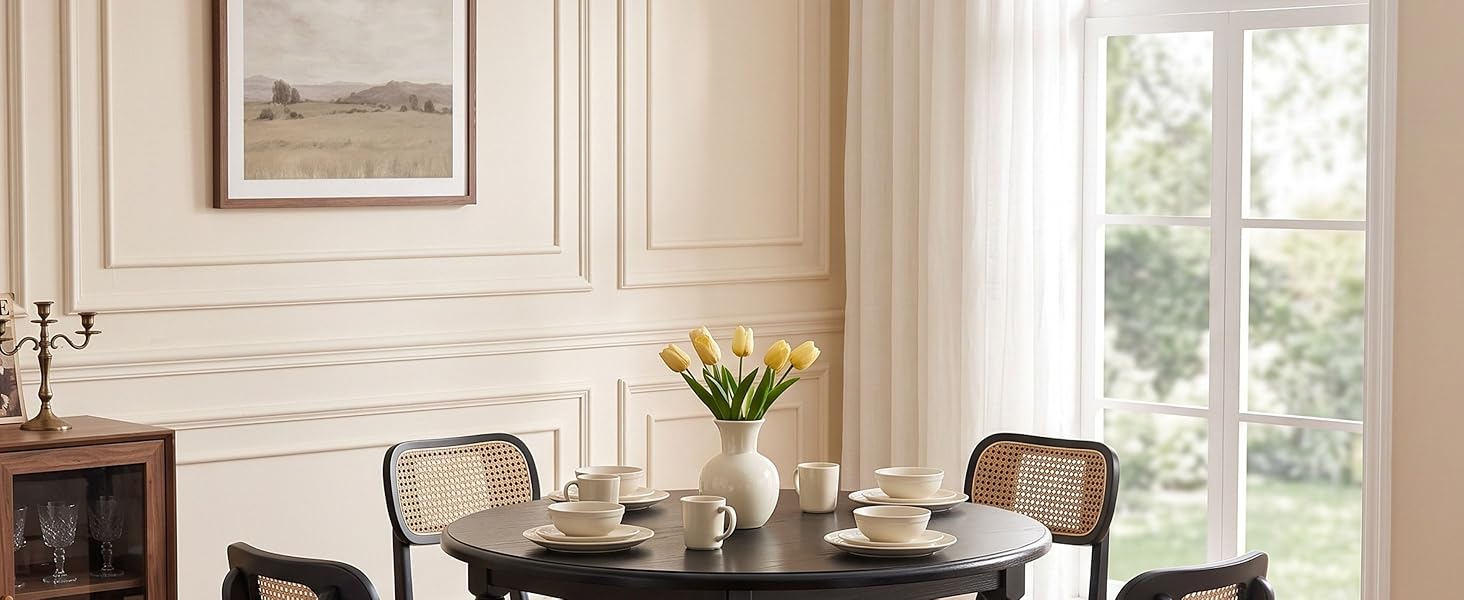 Intérieur élégant de la salle à manger avec murs en lambris blancs, table en bois avec couverts, cheminée sur la gauche, grande fenêtre à carreaux multiples avec lumière naturelle, pièce maîtresse en arrangement floral.