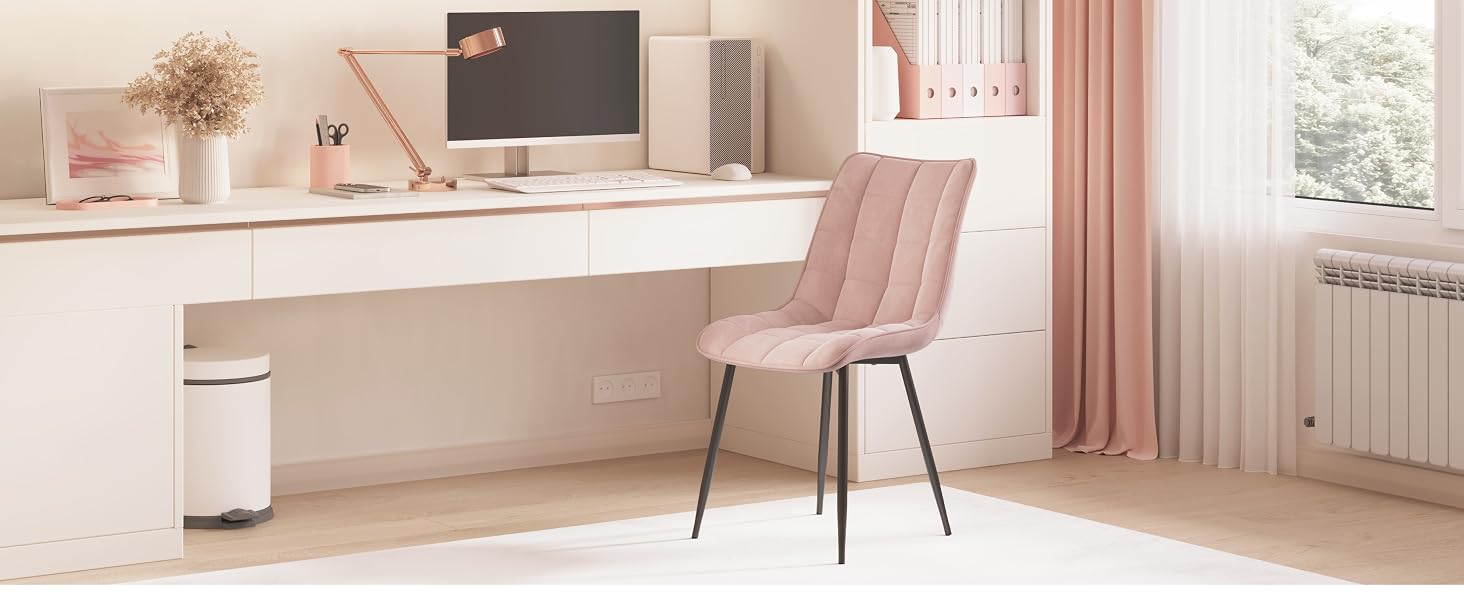 una sedia rosa davanti a una scrivania con un computer e un monitor.