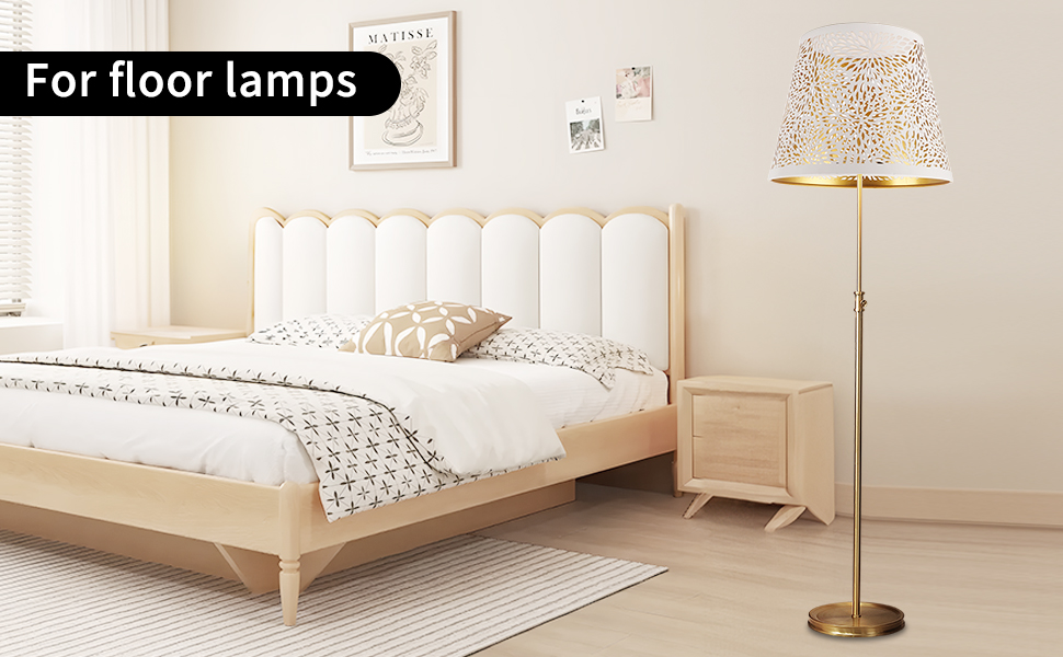 Chambre moderne dotée d'un lampadaire avec abat-jour décoratif, placé à côté d'un lit avec tête de lit blanche capitonnée et literie neutre
