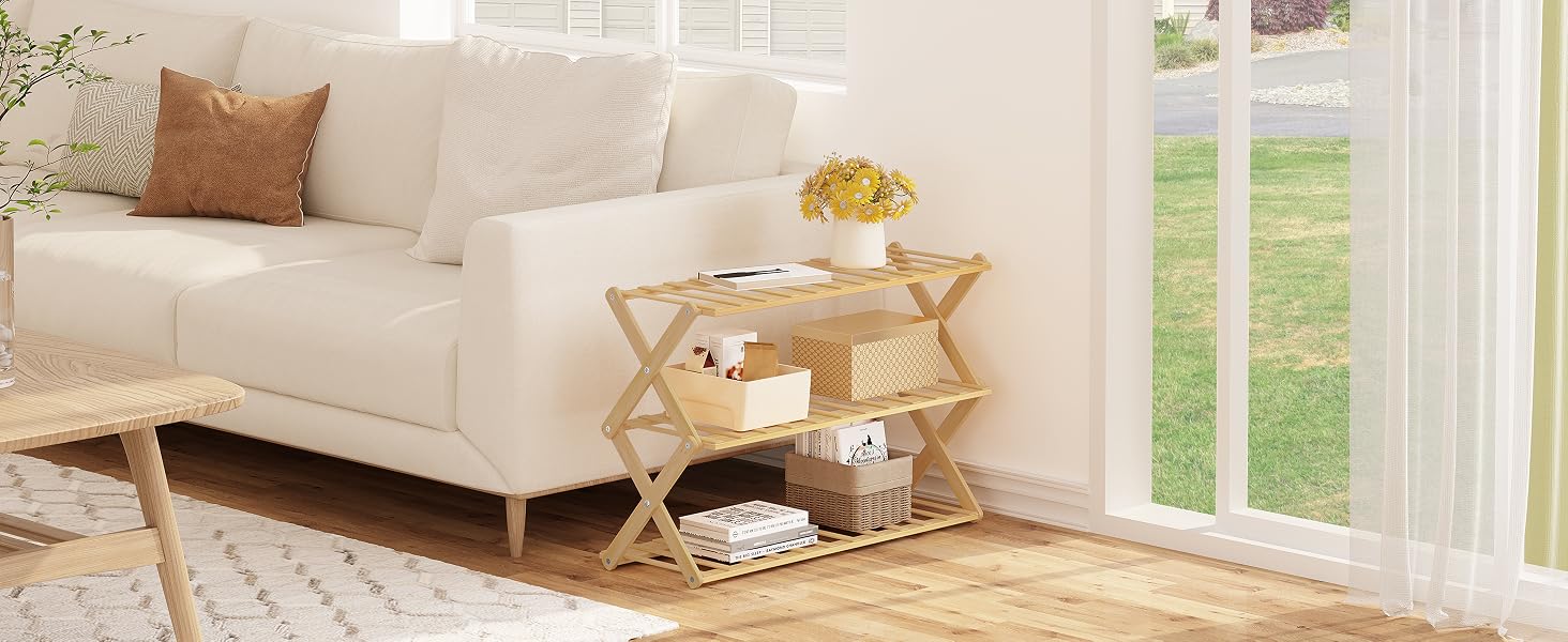 Living room scene with white sofa, patterned rug, and wooden folding side table. Natural light from window illuminates the space.