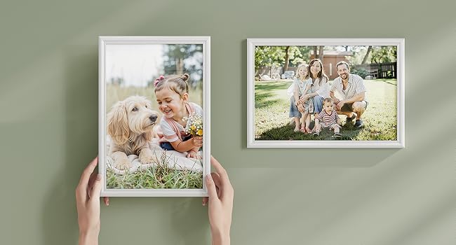 Raccolta di cornici per foto che mostrano più immagini disposte in un display in stile galleria a parete. Mostra varie fotografie di stile di vita e di famiglia in cornici bianche.