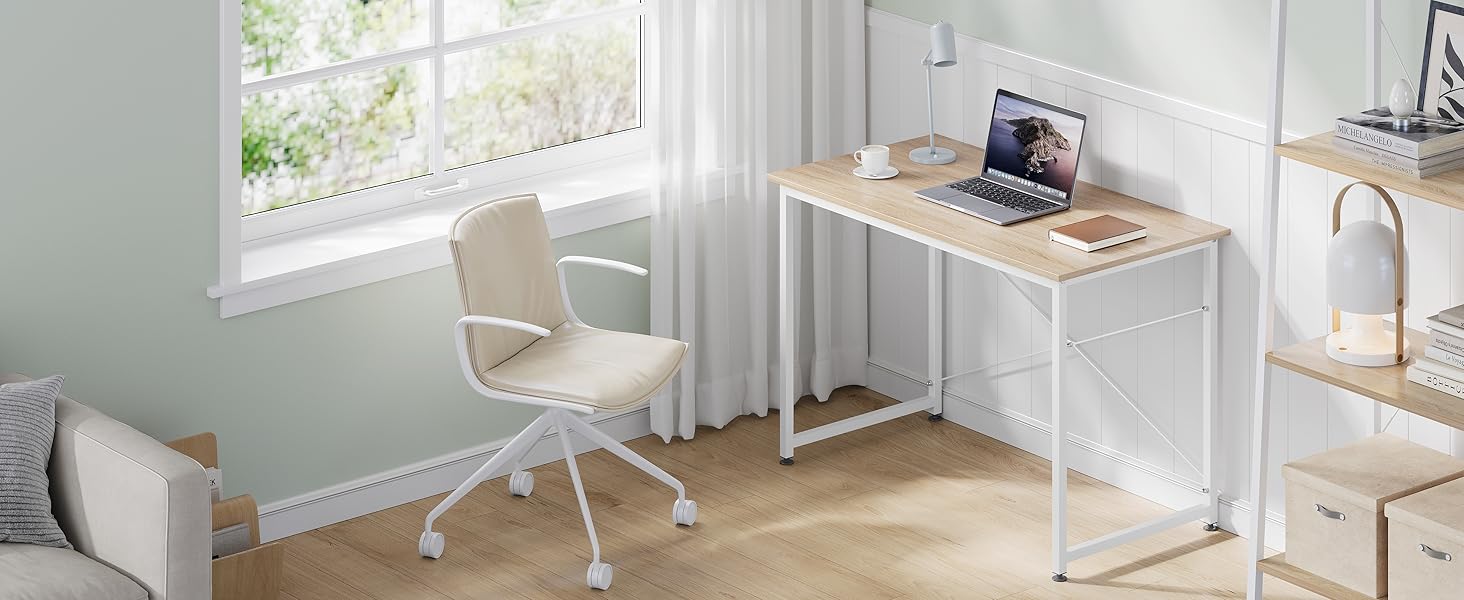 Configurazione minimalista per l'home office con scrivania in legno chiaro, sedia bianca e laptop vicino a una finestra luminosa in una stanza bianca