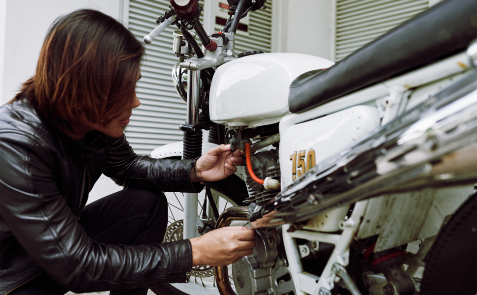 a man is fixing a motorcycle.