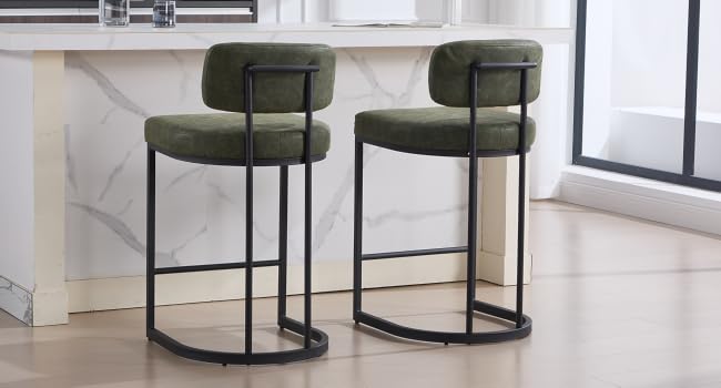 Modern dining chairs featuring dark green velvet upholstery and black circular metal frames, shown from multiple angles in a contemporary interior setting.