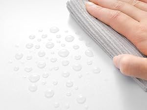 una persona que limpia un paño con gotas de agua