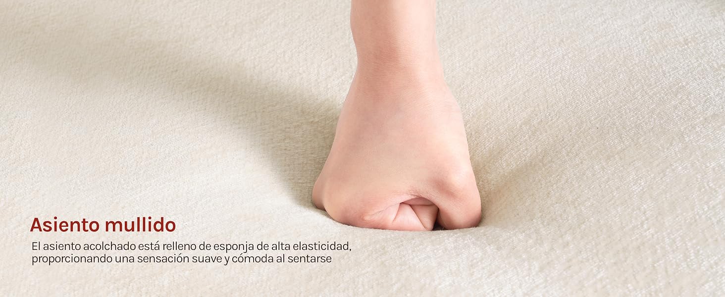 El texto dice «Asiento mullido» (asiento acolchado). Primer plano del pie sobre una superficie acolchada, con un acolchado de textura suave y un texto descriptivo en español en la parte inferior.