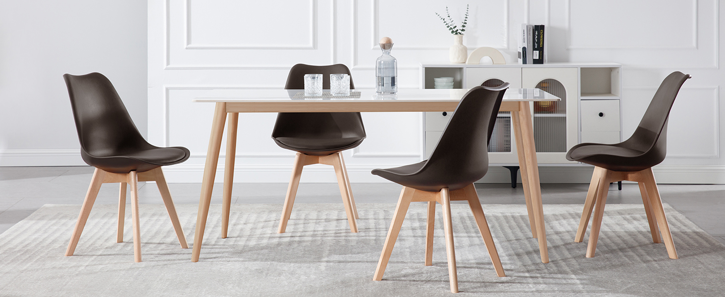 con mesa de madera y cuatro sillas negras de plástico moldeado con patas de madera en un ambiente luminoso y minimalista.