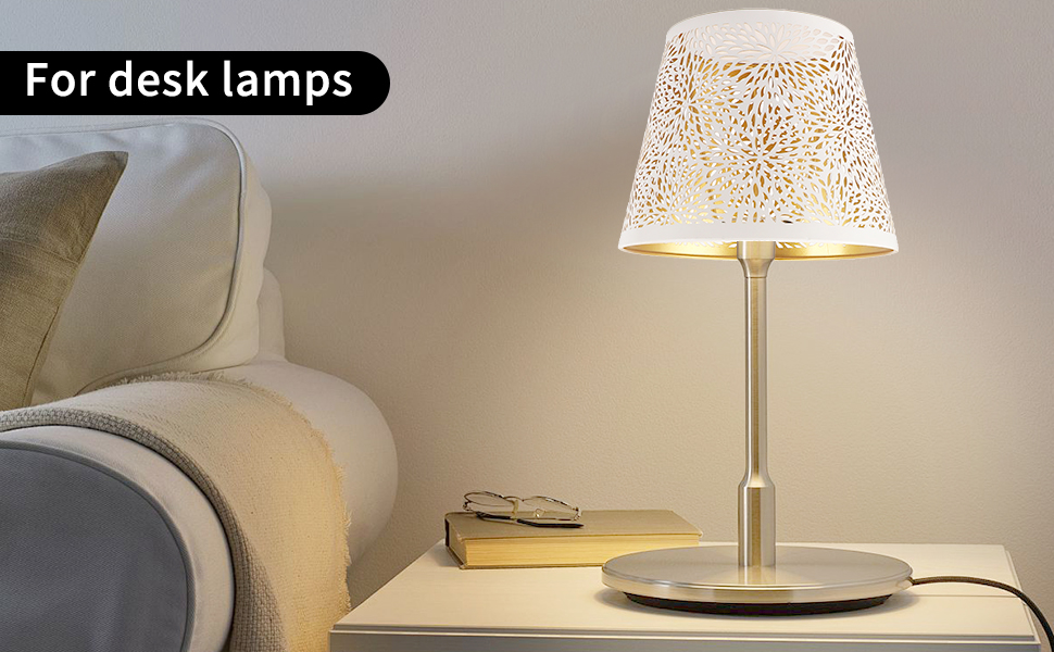avec un abat-jour en métal perforé émettant une lueur chaude. La lampe possède une base et une tige en métal élégantes, adaptées à une utilisation au chevet ou au bureau