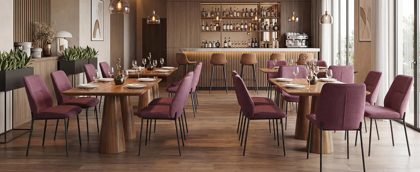 Sala da pranzo di lusso con tavolo in legno, otto sedie imbottite bordeaux con gambe in metallo, illuminazione a sospensione, scaffali con oggetti decorativi, pavimenti in legno caldo e pareti dai toni neutri.