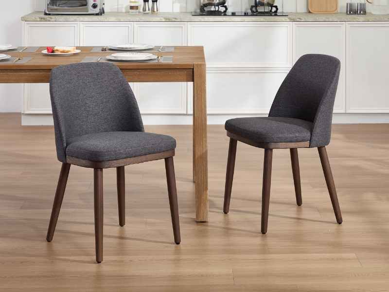 Múltiples vistas de sillas de comedor con tapicería gris y patas de madera cónicas dispuestas en una habitación con pisos de madera clara.
