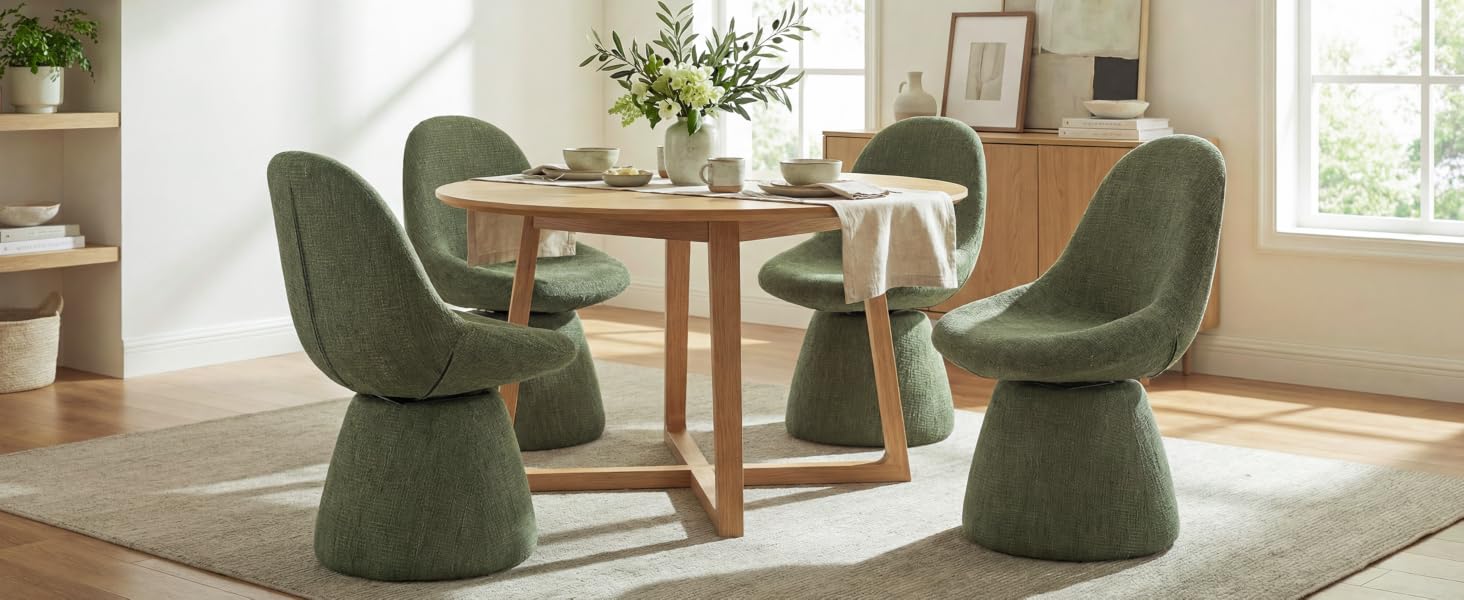 Modern living room setting with olive green swivel lounge chairs and round wooden dining table. Interior features warm lighting and minimalist decor with plants.