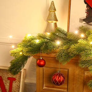 avec guirlande de pin illuminée, décoration d'arbre doré et boules rouges accrochées