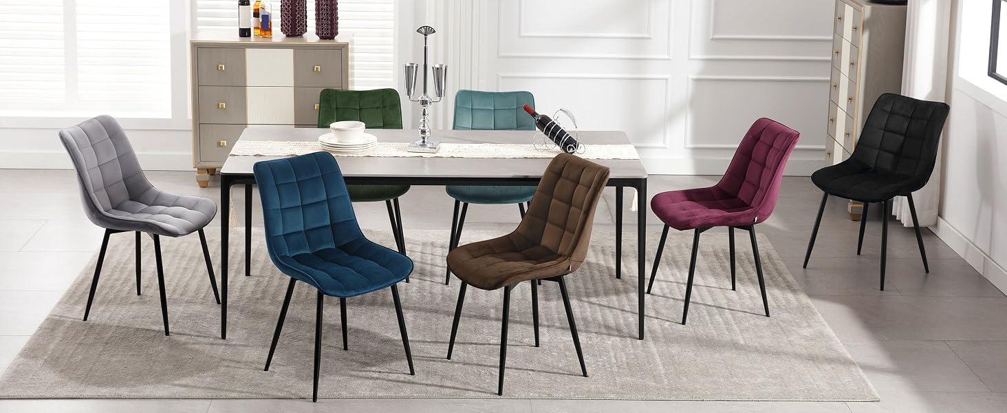 con sillas acolchadas en varios colores, incluidos azul, morado, marrón y negro, dispuestas alrededor de una mesa blanca sobre una alfombra gris