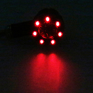 Circular array of red LED lights glowing in darkness. Arranged in a flower-like pattern with six outer lights and one center light.