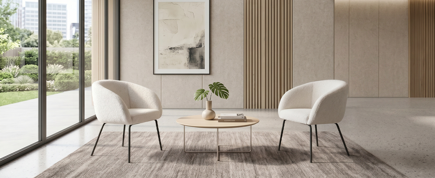 Modern minimalist interior space with two cream/beige armchairs facing each other across round side table, large window, potted plant, neutral walls with vertical paneling, light area rug on polished concrete floor.