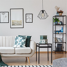 a living room with a white couch, a black table, and a lamp.