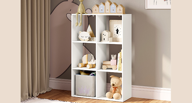 Contenitore verticale bianco con sei scomparti cubici contenenti giocattoli, scatole portaoggetti e oggetti decorativi, posizionato contro una parete beige