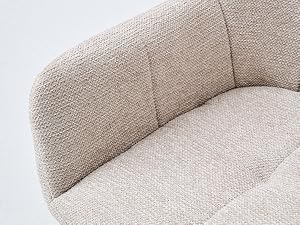 Dossier incurvé rembourré beige avec rembourrage doux et texture capitonnée visible depuis l'angle latéral.