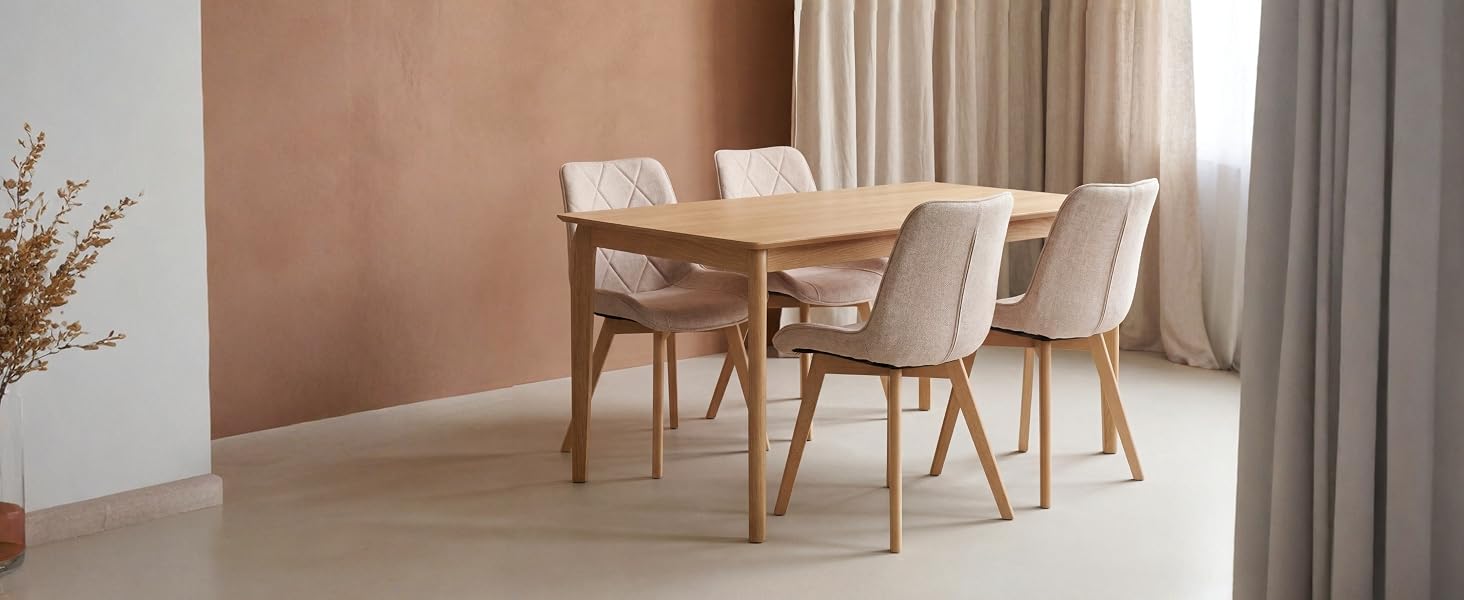 Ensemble de salle à manger de style scandinave avec table rectangulaire en bois clair et deux chaises rembourrées avec pieds en bois dans un intérieur chaleureux avec rideaux.