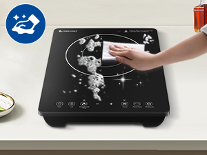 Schwarzes Induktionskochfeld wird gereinigt. Es zeigt Touchpad-Bedienelemente und eine glatte Glasoberfläche mit Reinigungsdemonstration