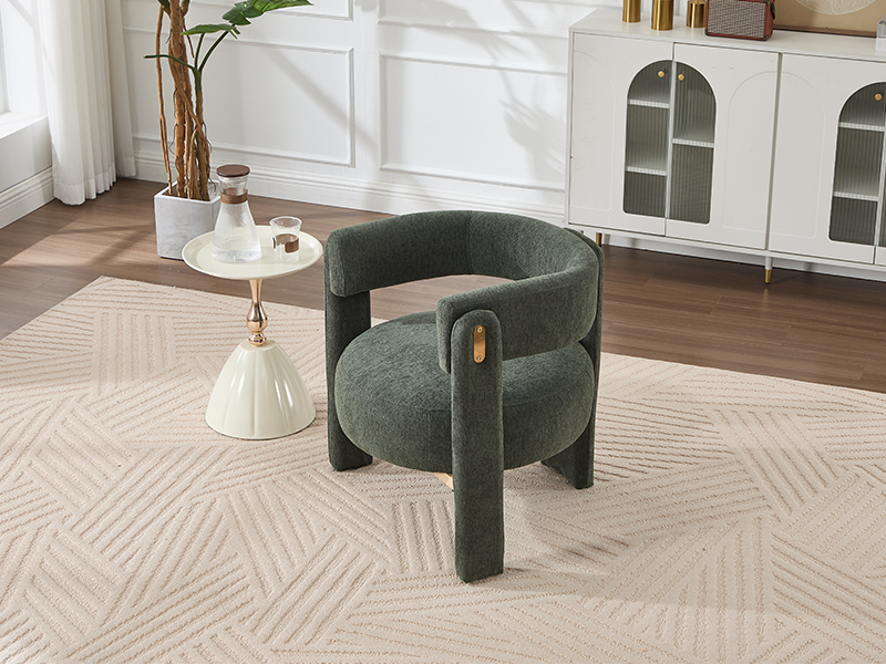 Modern curved armchair in dark gray fabric with distinctive sculptural form, positioned on beige carpeted floor with white architectural details visible.