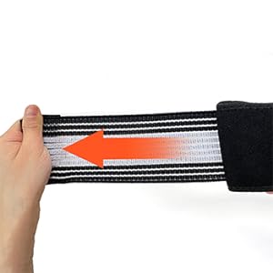 Close-up of a black and white striped elastic band with an orange arrow indicating stretch direction.